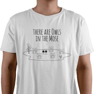 Billede af en hvid t-shirt med ordsproget "ugler i mosen". Det er en mose med 6 ugler i. Ovenover står der "When there are owls in the mose" som er en reference til det danske ordsprog og talemåde.